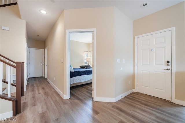 entryway with recessed lighting, light wood-type flooring, baseboards, and stairs