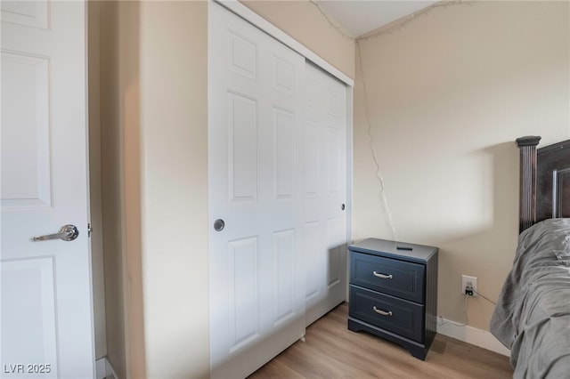 bedroom featuring a closet, baseboards, and light wood finished floors