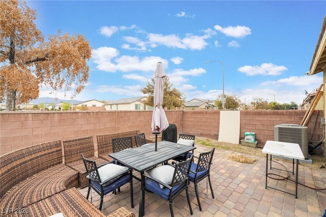 view of patio featuring a fenced backyard, cooling unit, and outdoor dining space