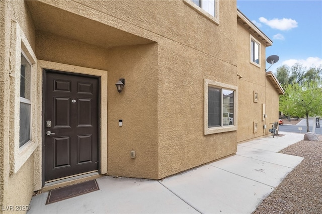 view of exterior entry featuring stucco siding