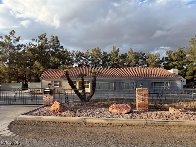 view of front of home with a tile roof and a fenced front yard