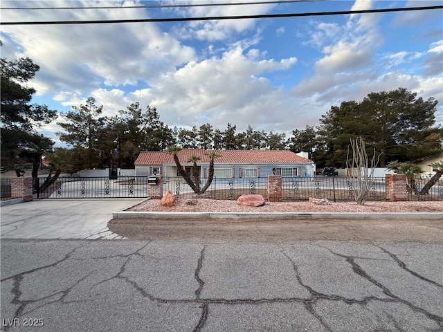 view of front of property featuring a fenced front yard and a tile roof