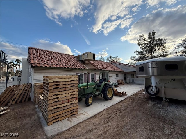 exterior space featuring fence and a tiled roof