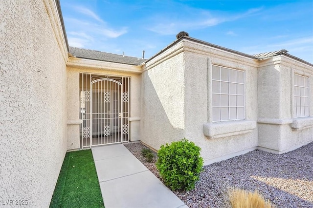 doorway to property featuring stucco siding