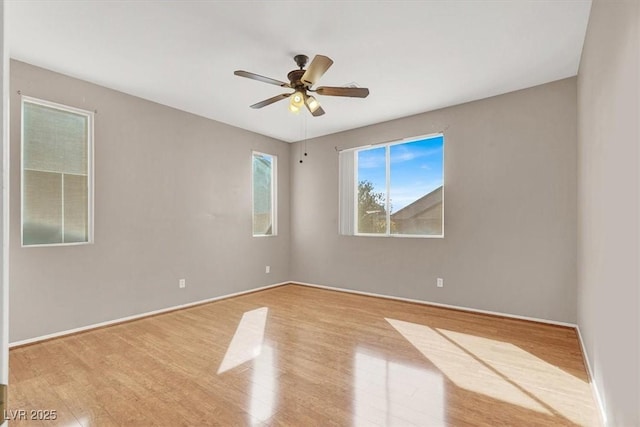 spare room featuring baseboards, a ceiling fan, and wood finished floors