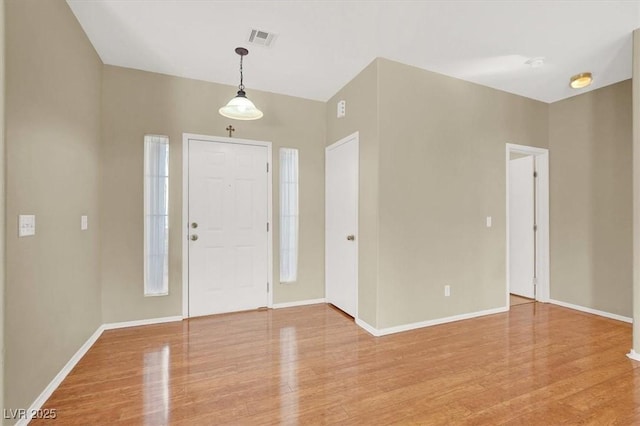 entryway with baseboards, visible vents, and light wood-type flooring