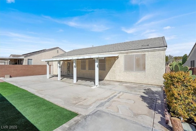 back of property featuring stucco siding, a patio, and fence