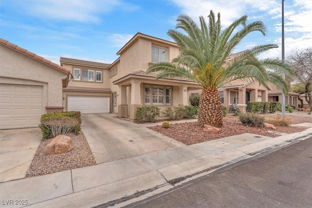 view of front of house with concrete driveway, an attached garage, and stucco siding