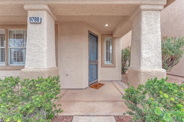 view of exterior entry featuring stucco siding