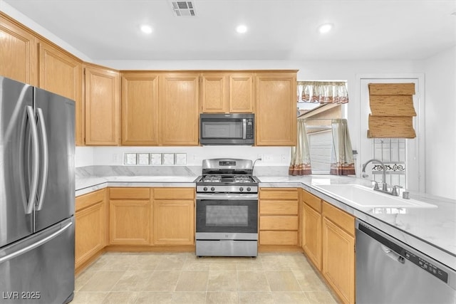 kitchen with visible vents, appliances with stainless steel finishes, light countertops, and a sink