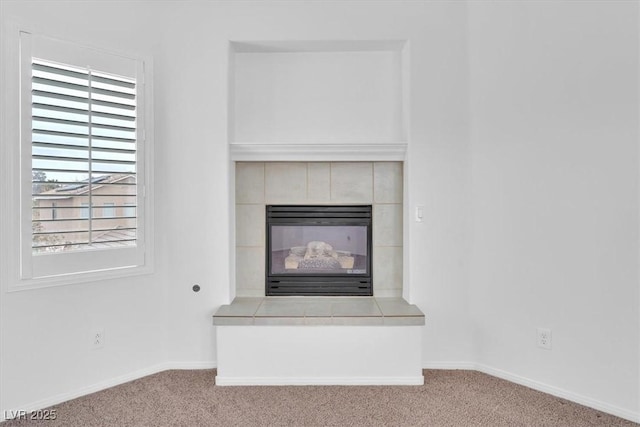 interior details featuring baseboards, carpet, and a fireplace