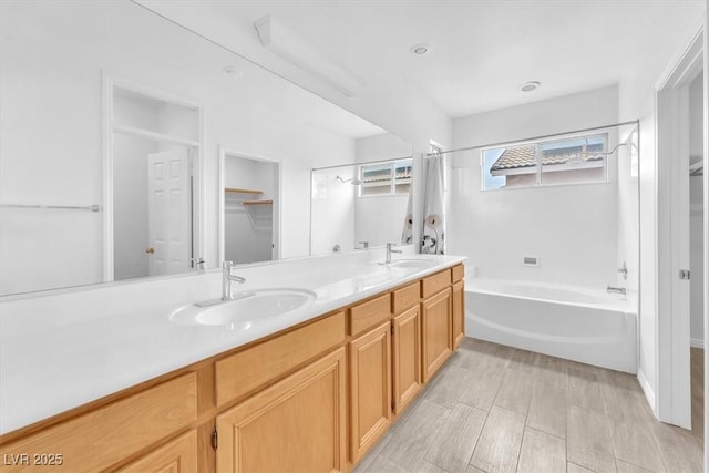 bathroom with double vanity, shower / tub combo with curtain, and a sink