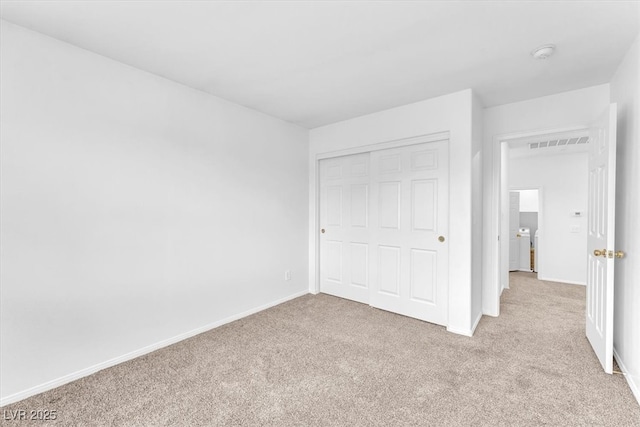 unfurnished bedroom with visible vents, baseboards, light colored carpet, and a closet