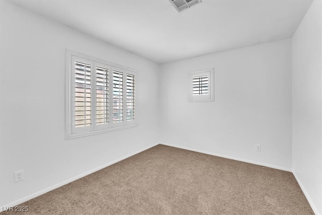 empty room featuring visible vents, carpet flooring, and baseboards