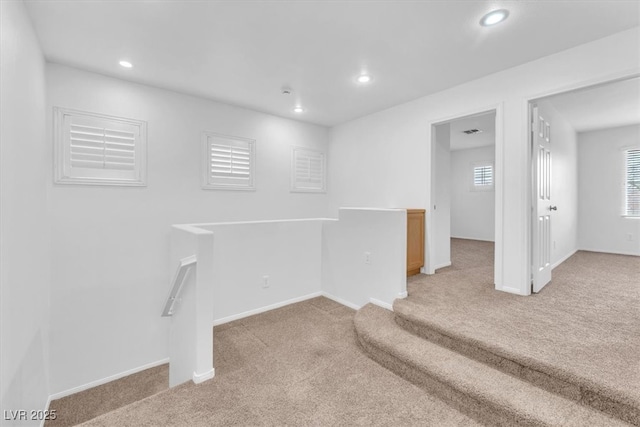 basement featuring recessed lighting, baseboards, and light carpet