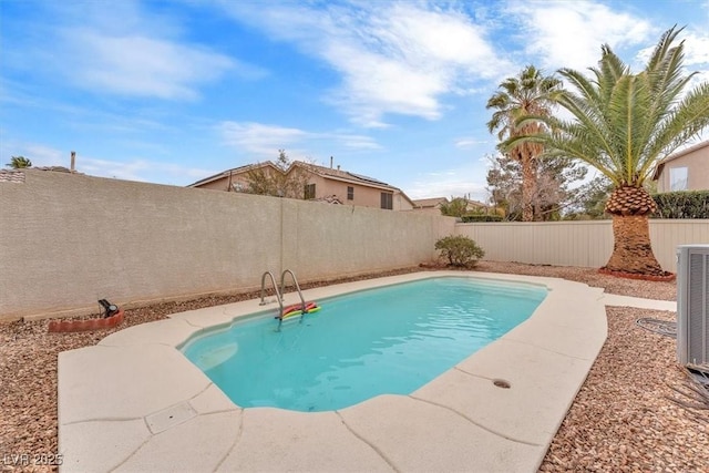 view of swimming pool with cooling unit and a fenced backyard