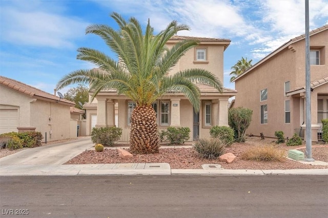 mediterranean / spanish-style house with an attached garage, driveway, and stucco siding