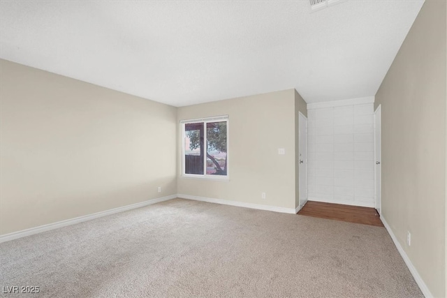 carpeted empty room with baseboards