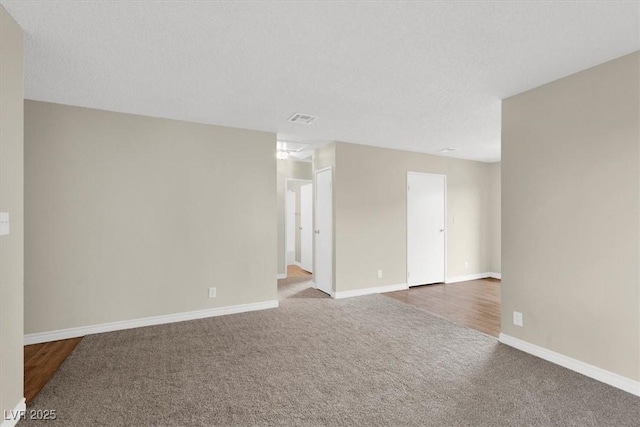 carpeted empty room featuring visible vents and baseboards