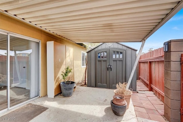 view of patio / terrace with a storage shed, an outdoor structure, and fence