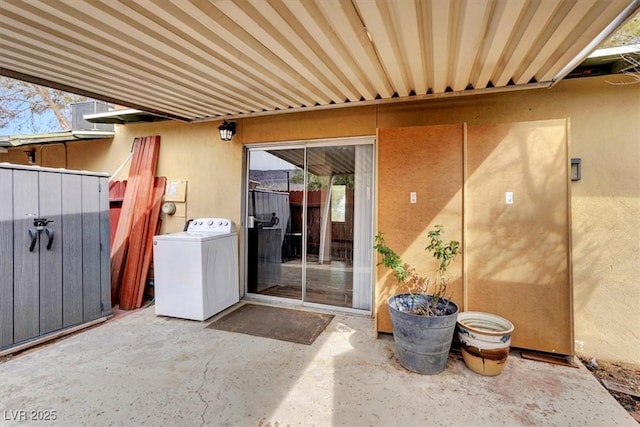 view of patio / terrace featuring washer / dryer and fence