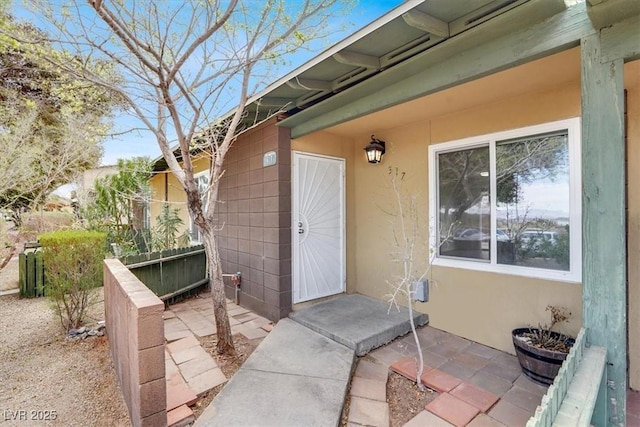 entrance to property featuring stucco siding