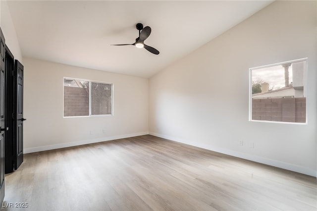 empty room with a ceiling fan, lofted ceiling, light wood-style floors, and a wealth of natural light