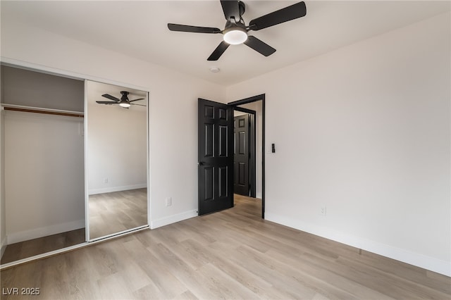 unfurnished bedroom featuring light wood-type flooring, baseboards, a closet, and a ceiling fan