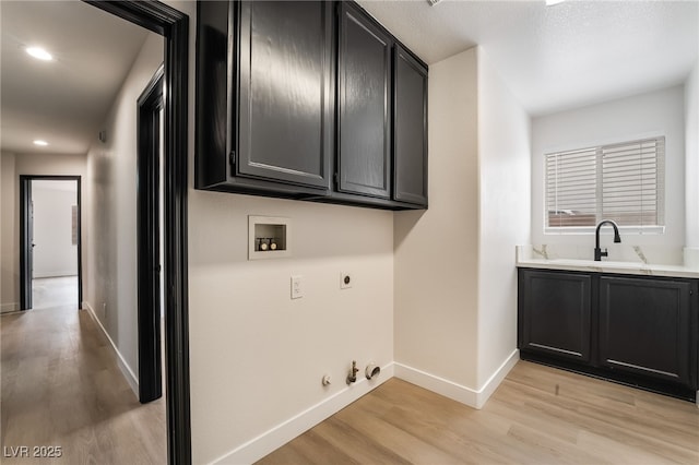 laundry room featuring hookup for a washing machine, light wood-style flooring, hookup for a gas dryer, hookup for an electric dryer, and a sink