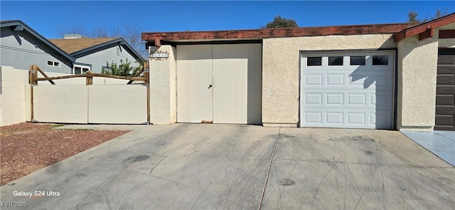 garage with fence and driveway