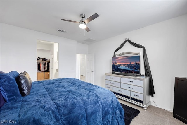 bedroom with visible vents, a ceiling fan, a spacious closet, and carpet flooring