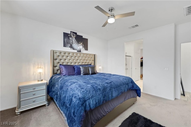 bedroom with visible vents, a ceiling fan, ensuite bathroom, and carpet