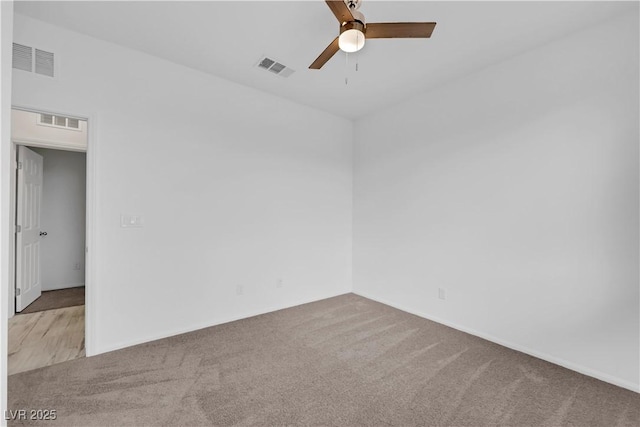 spare room with visible vents, carpet flooring, and a ceiling fan