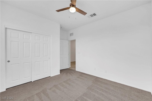 unfurnished bedroom with carpet, visible vents, a closet, and ceiling fan