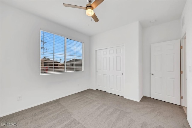 unfurnished bedroom featuring visible vents, a closet, carpet floors, baseboards, and ceiling fan