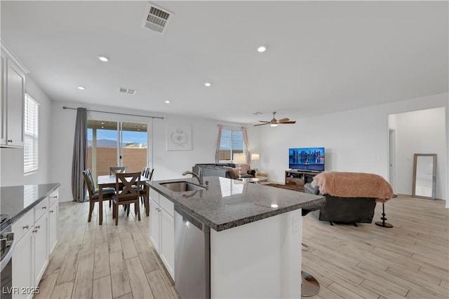 kitchen with a sink, visible vents, light wood-style floors, and stainless steel dishwasher