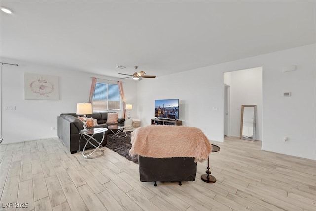 living area with light wood-type flooring and ceiling fan