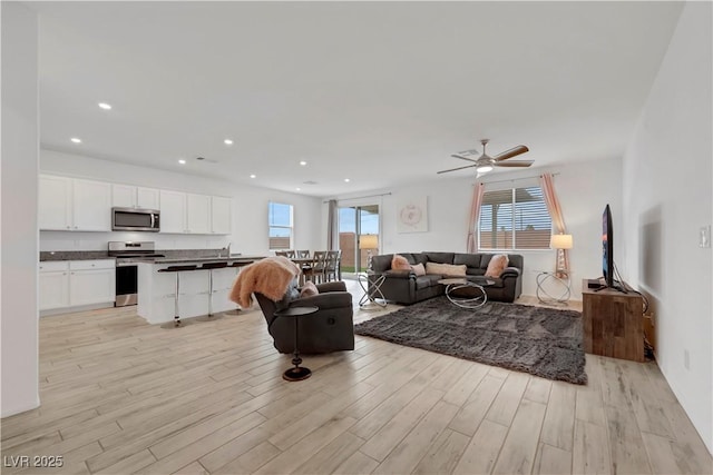 living area with recessed lighting, a healthy amount of sunlight, and light wood-type flooring