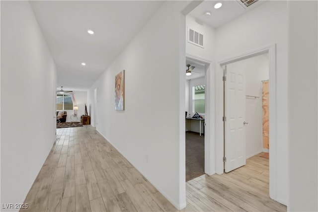 corridor with light wood-style flooring, recessed lighting, and visible vents