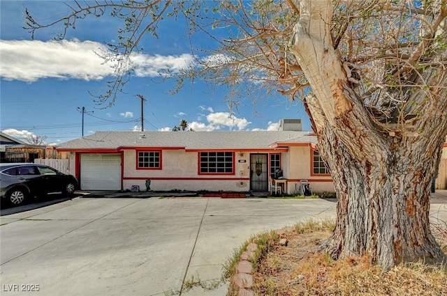 single story home with concrete driveway, fence, a garage, and stucco siding