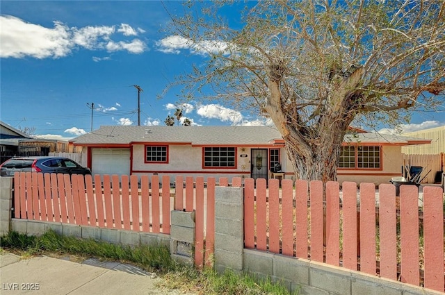 ranch-style home with an attached garage and a fenced front yard