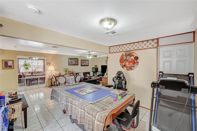 playroom with light tile patterned floors, visible vents, ceiling fan, and ornamental molding