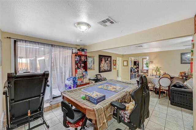 dining space with light tile patterned floors, visible vents, and a textured ceiling