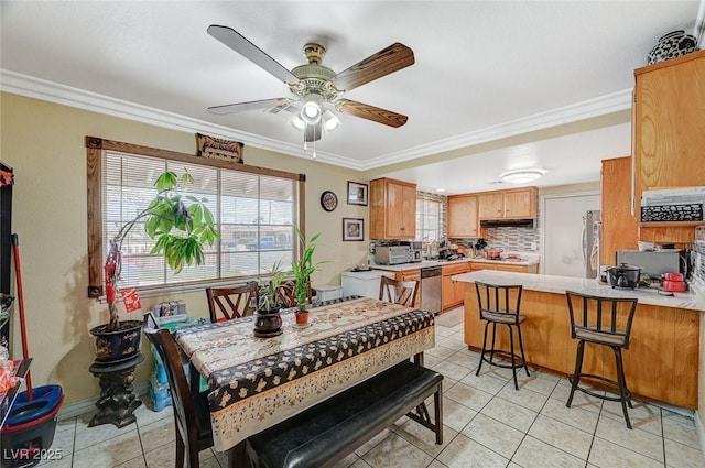 dining space with ceiling fan, light tile patterned flooring, and ornamental molding