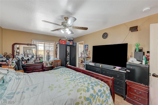 bedroom featuring a textured ceiling, a ceiling fan, and wood finished floors