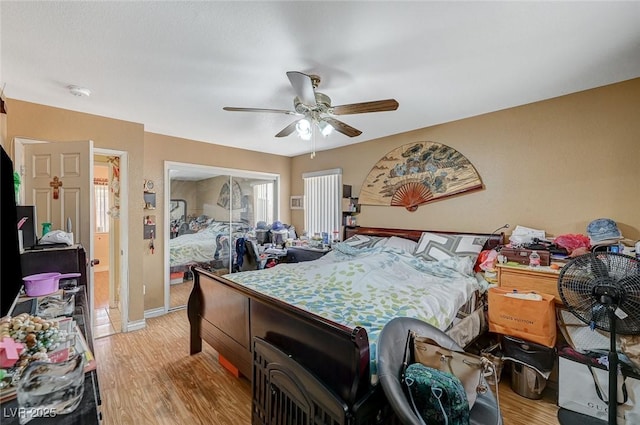 bedroom with a closet, baseboards, ceiling fan, and light wood finished floors