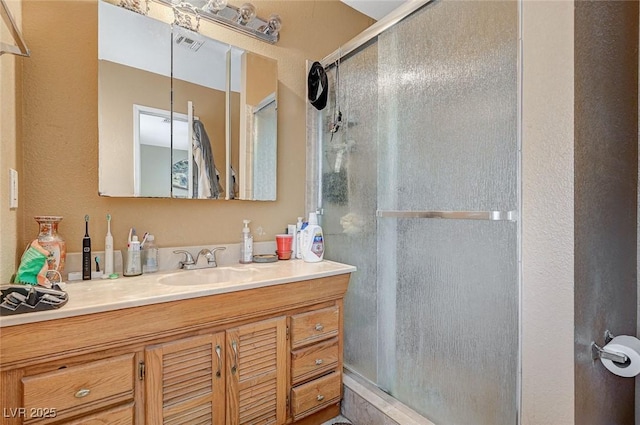 full bath with visible vents, a stall shower, and vanity