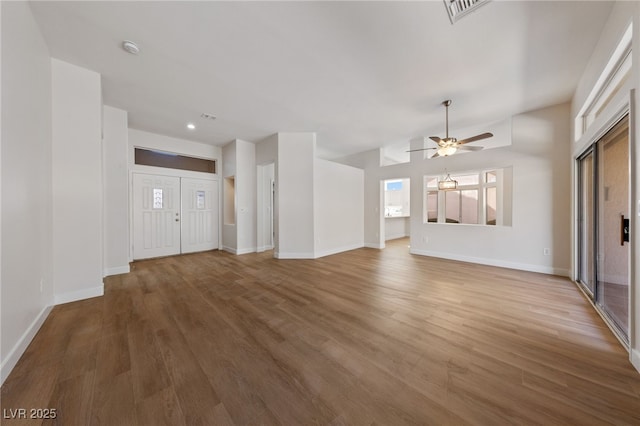 unfurnished living room featuring visible vents, baseboards, and wood finished floors