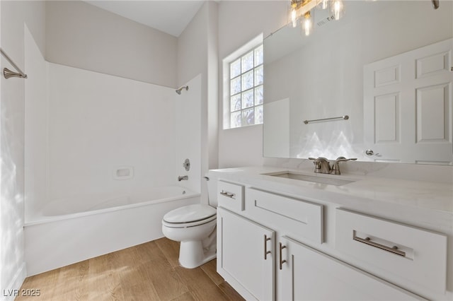 full bathroom featuring visible vents, toilet, wood finished floors, bathing tub / shower combination, and vanity