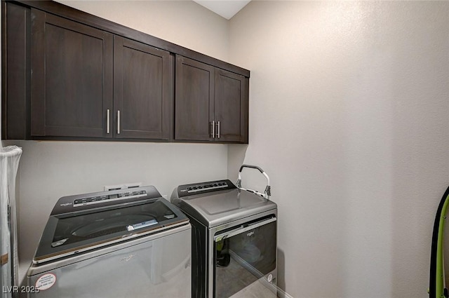 washroom with washer and dryer and cabinet space